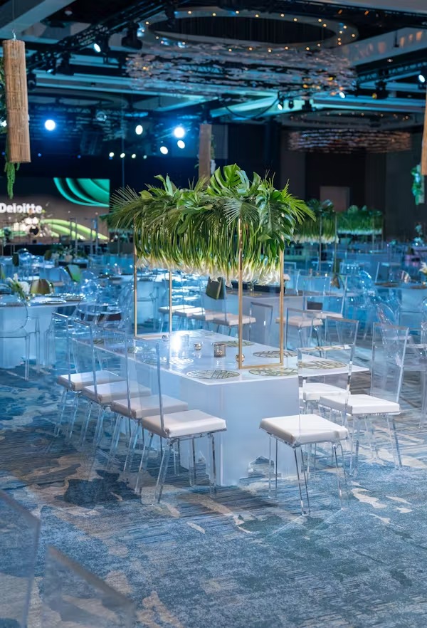 Corporate gala table beneath a suspended installation of white calla lilies and tropical greenery