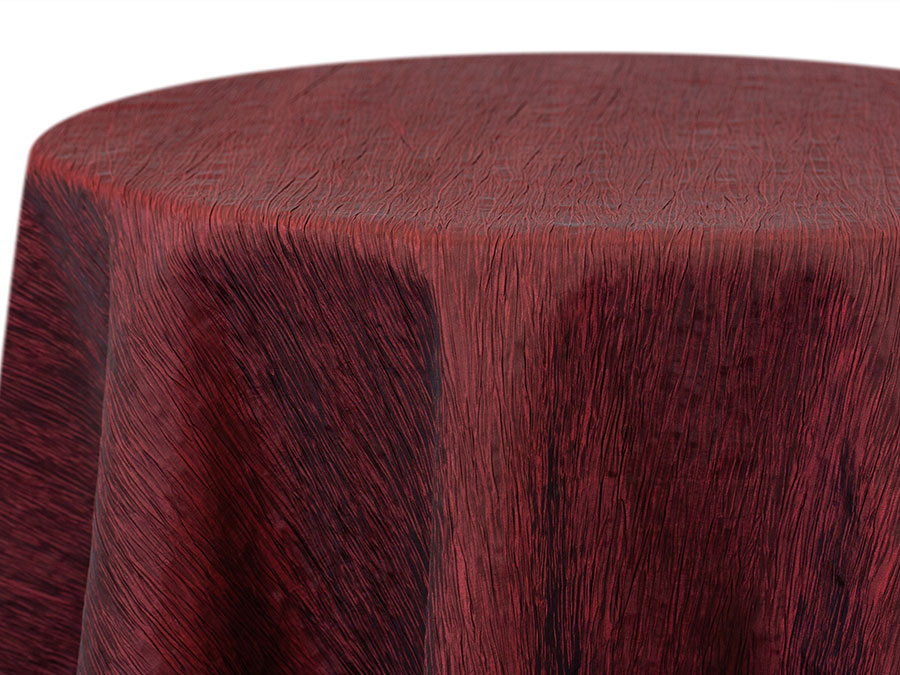 Deep crimson crinkle-texture tablecloth draped over a round table