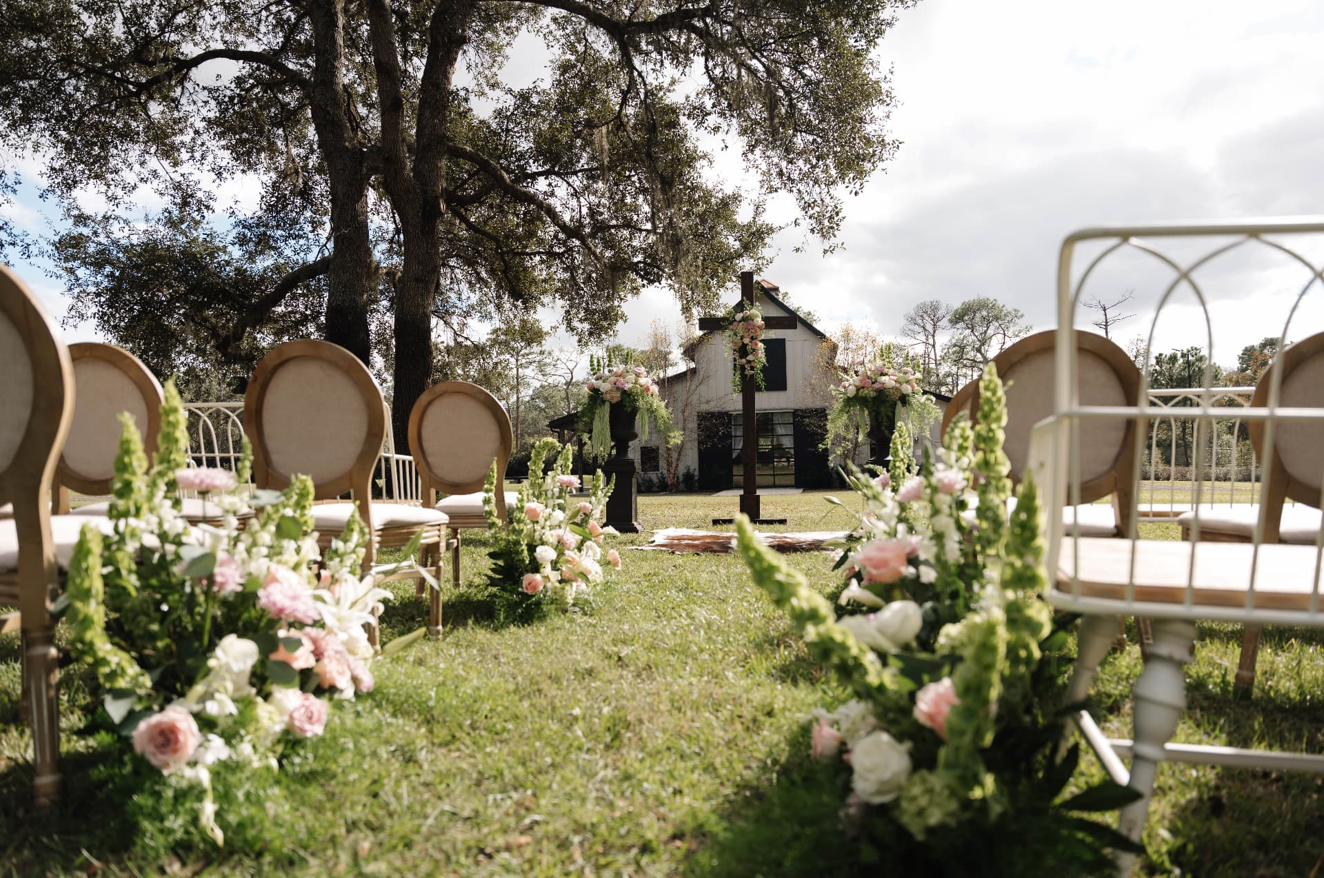 Ceremony aisle lined with flowers and vintage chairs