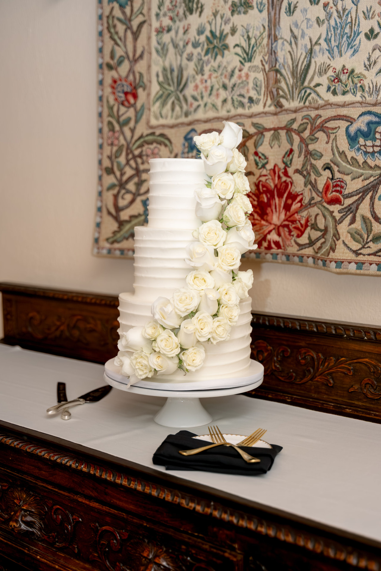 White wedding cake with cascading roses