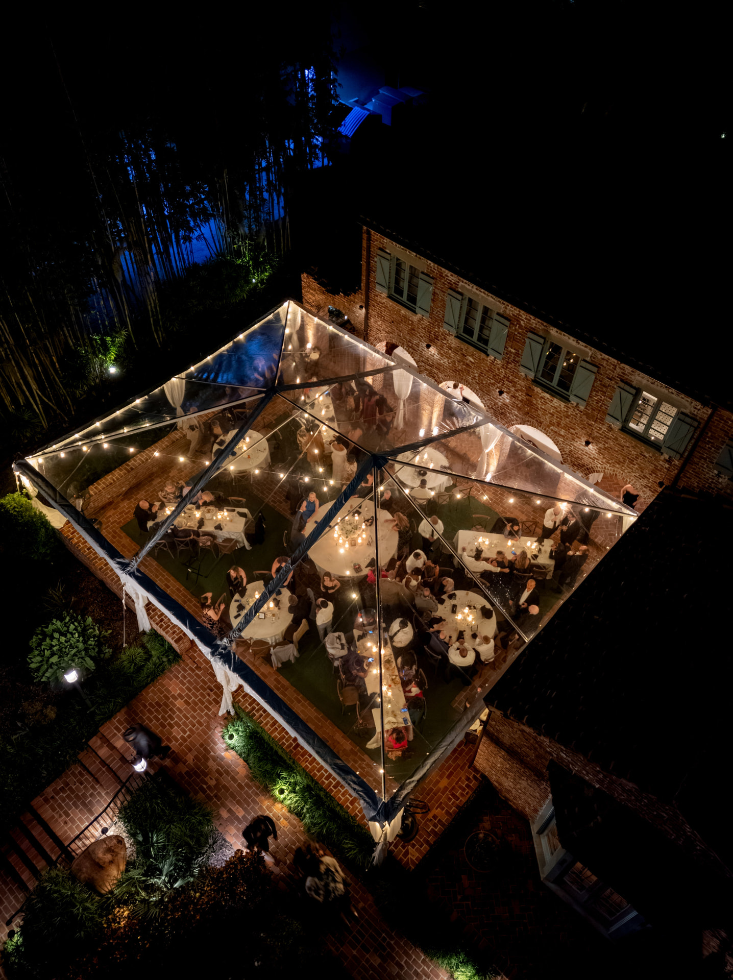 Aerial view of a candlelit tented reception at night
